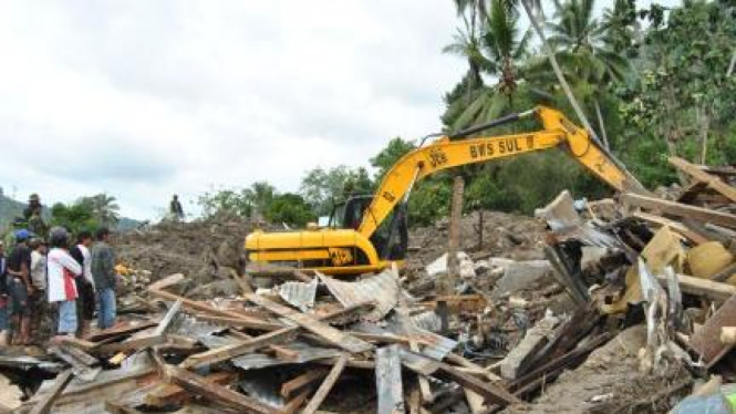 Alat berat mengeruk timbunan material akibat banjir di Sigi, Sulawesi Tengah