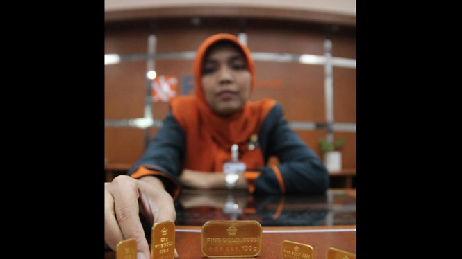 Pegawai Memperlihatkan Emas Batangan di Bank BNI Syariah