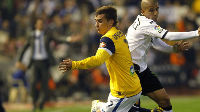 Pemain Sociedad Antoine Griezmann (kiri) berduel dengan pemain Valencia
