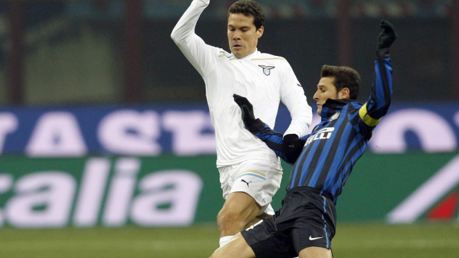 Kapten Inter Milan, Javier Zanetti (kanan) berebut bola dengan Hernanes