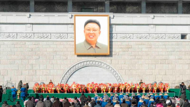 Warga Korut memberikan karangan bunga di depan foto Kim Jong-il