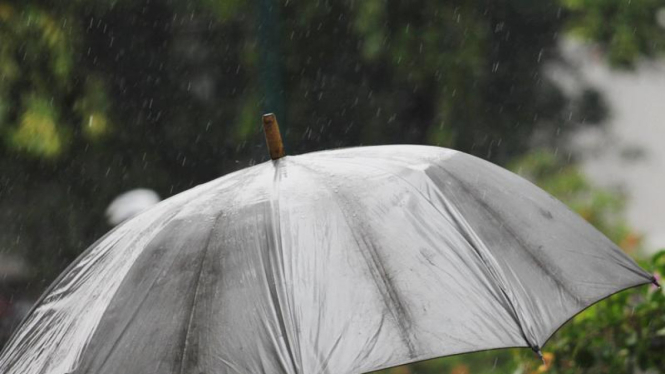 Seorang pejalan kaki menggunakan payung saat turun hujan, Jakarta, Senin (30/04/2012). 