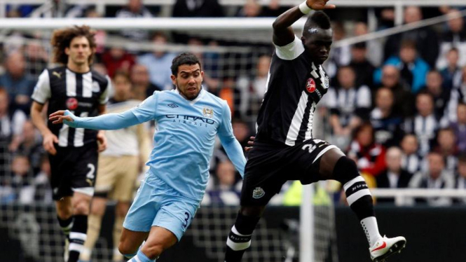 Gelandang Newcastle Cheick Tiote (kanan) berebut bola dengan Carlos Tevez