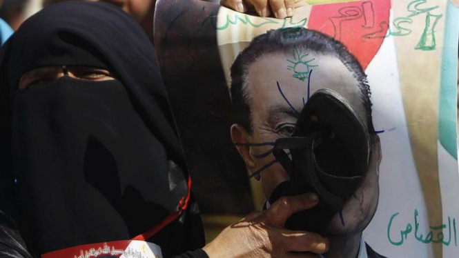 Seorang demonstran pukulkan sandal ke gambar Hosni Mubarak 