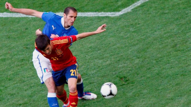 Pemain Spanyol, David Silva, berebut bola dengan Giorgio Chiellini