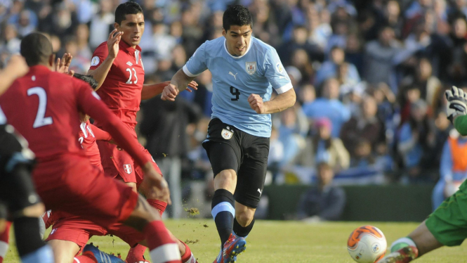 Luis Suarez (tengah) melewati hadangan para pemain Peru