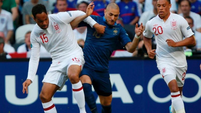 Pemain Inggris, Joleon Lescott (kiri/putih) dan Karim Benzema berebut bola