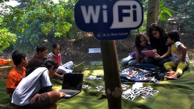 Sejumlah anak sedang menggunakan fasilitas free Wifi di kawasan Kali Ciliwung Condet, Jakarta, Sabtu (14/7/2012)