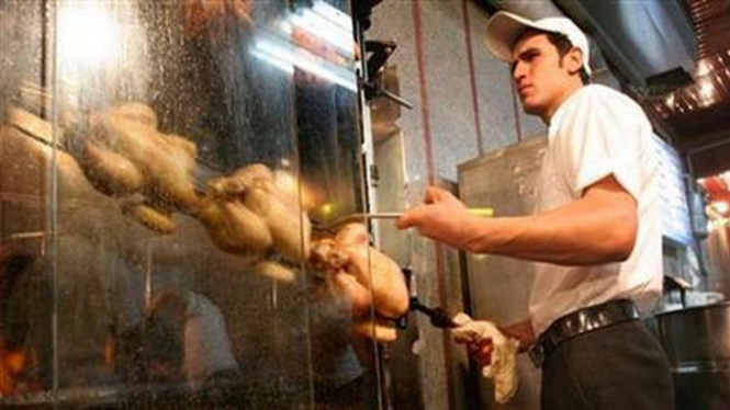 Seorang pria di Teheran sedang memanggang daging ayam