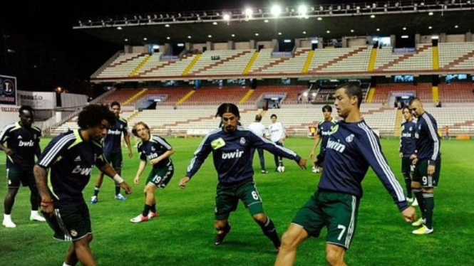 Pemain Real Madrid melakukan pemanasan dengan latar lampu yang tak menyala