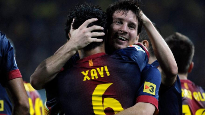 Xavi Hernandez (6) merayakan gol Lionel Messi