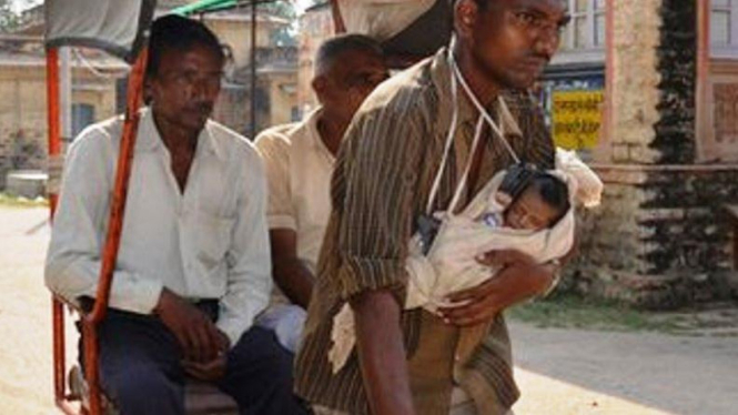 Bablu Jatav menarik becak sambil menggendong bayi