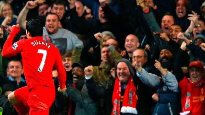 Pemain Liverpool, Luis Suarez, merayakan golnya di depan suporter