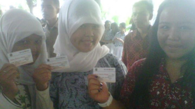 Siswa memegang "Kartu Jakarta Pintar"