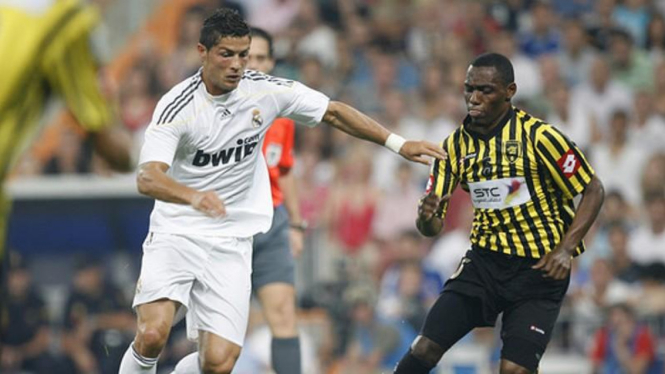 Pemain Al-Ittihad (kanan) berebut bola dengan Cristiano Ronaldo