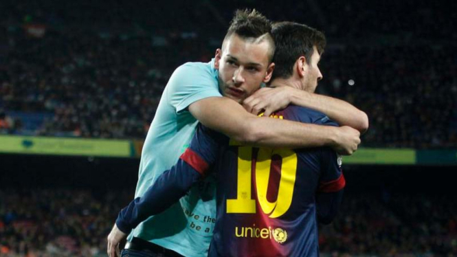 Lionel Messi dipeluk suporter saat Barcelona menghadapi Ateltico Madrid