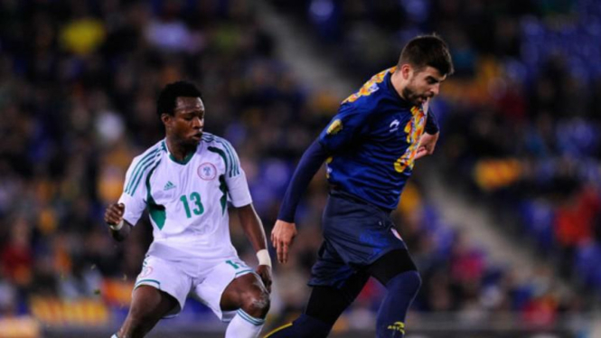 Gerard Pique berebut bola dengan pemain Nigeria