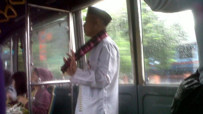 Petugas TransJakarta menggunakan baju adat Betawi.