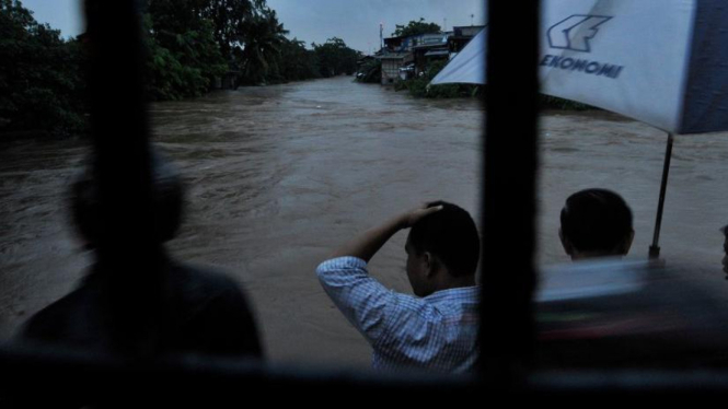 Warga menonton banjir di Kali Ciliwung Kampung Melayu