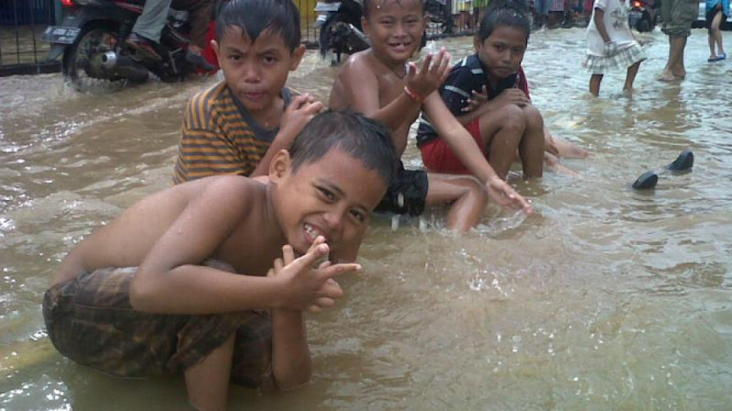 Anak-anak bermain air banjir