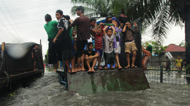 Menaiki Kendaraan Besar Untuk Melintasi Banjir