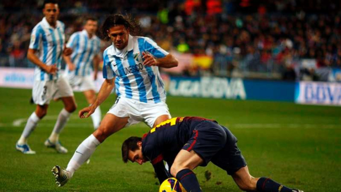 Martin Demichelis (kiri) berduel dengan Lionel Messi