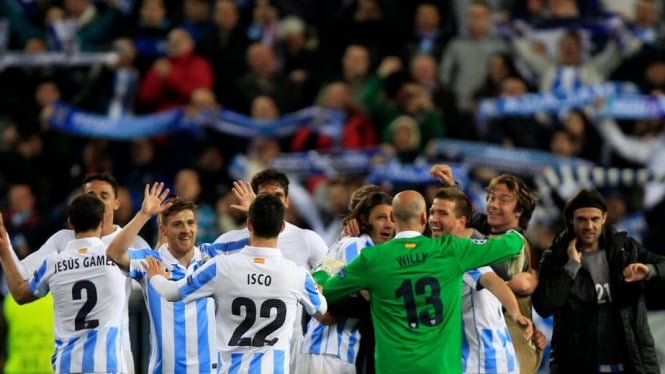 Pemain Malaga merayakan kemenangan atas Porto