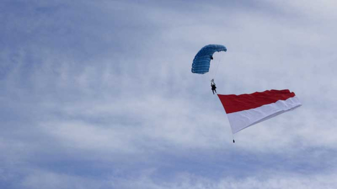 Penerjun membawa Bendera merah Putih saat peringatan HUT TNI AU