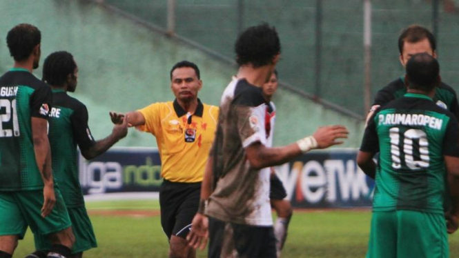 Wasit (kuning) tampak mengucurkan darah dari wajahnya