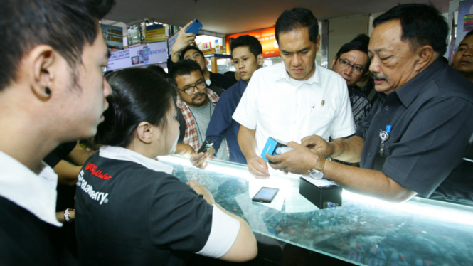 Menteri Perdagangan Gita Wirjawan memeriksa kartu garansi terkait peredaran telepon seluler (ponsel) ilegal di Pusat Perbelanjaan Roxy, Jakarta, Rabu (8/5/2013)
