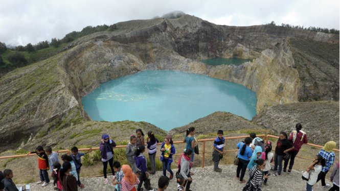 Wisatawan menikmati pemandangan dua danau yang diyakini warga setempat sebagai tempat arwah orang jahat.