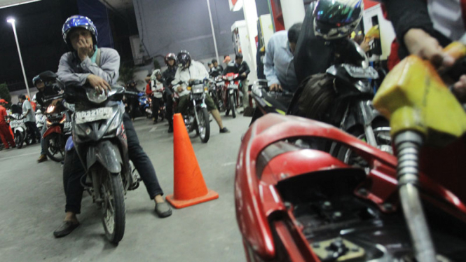 Pengendara sepeda motor mengantri untuk melakukan pengisian BBM jenis premium.