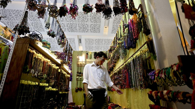 Seorang pekerja merapikan barang dagangannya di Jakarta