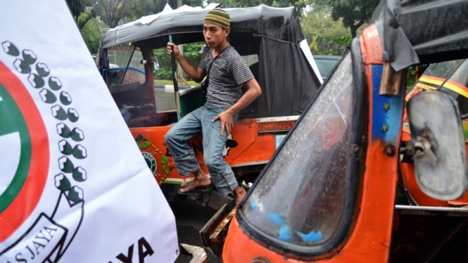 Puluhan sopir bajaj melakukan aksi unjuk rasa di depan kantor Gubernur DKI Jakarta, Kamis (4/7/2013). 