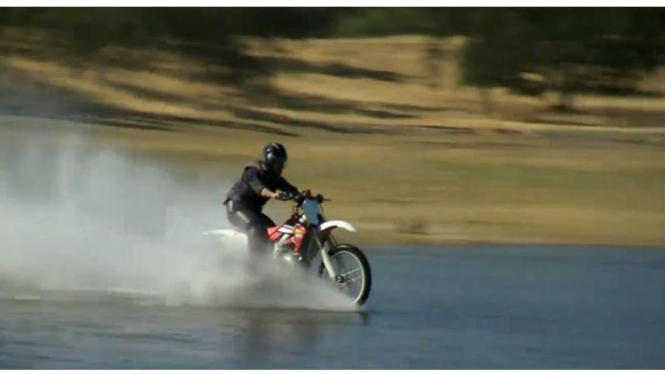 Aksi melintas di atas permukaan air menggunakan sepeda motor