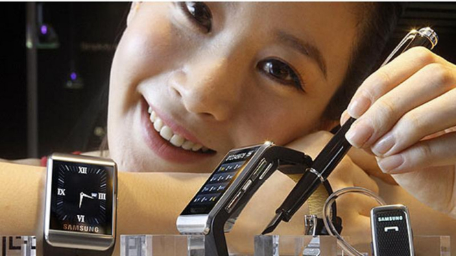 Seorang model perlihatkan ponsel pintar Samsung berbentuk jam tangan