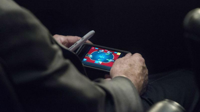 Senator John McCain asyik main game poker di ponsel