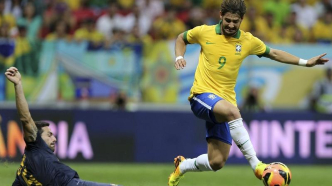 Pemain Brasil, Pato (kanan), menghindari pemain lawan