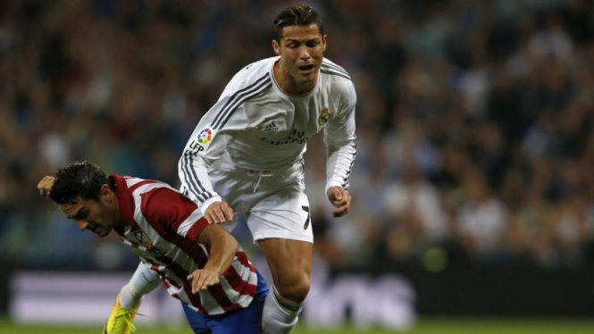 Pemain Real Madrid, Cristiano Ronaldo, terjatuh saat menghadapi Atletico Madrid