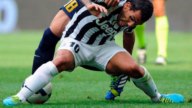 Pemain Juventus, Carlos Tevez, dalam perebutan bola