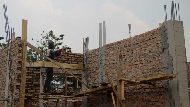 Pekerja melakukan proses pembangunan rumah