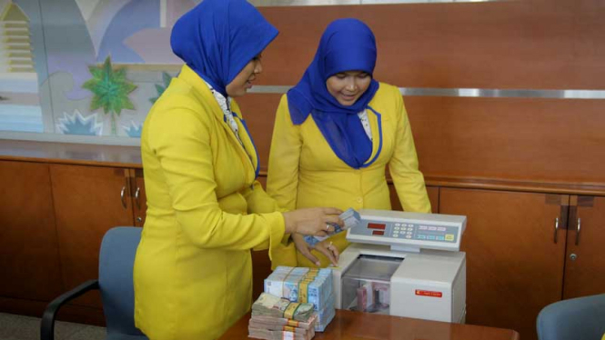 Teller menghitung uang Rupiah di Bank BJB, Depok, Jawa Barat.