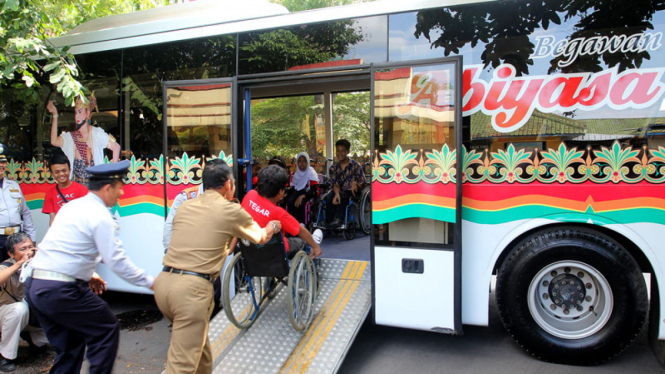 wali kota mendorong kursi roda penumpang bus