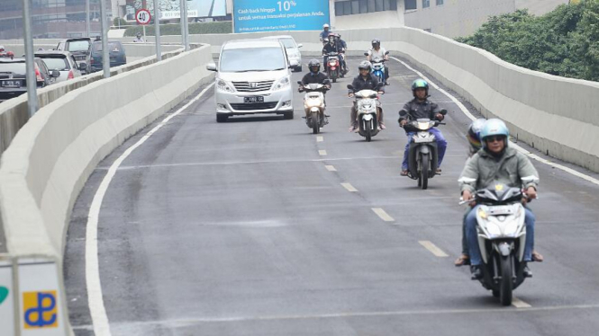 Ilustrasi pengendara motor di jalan.