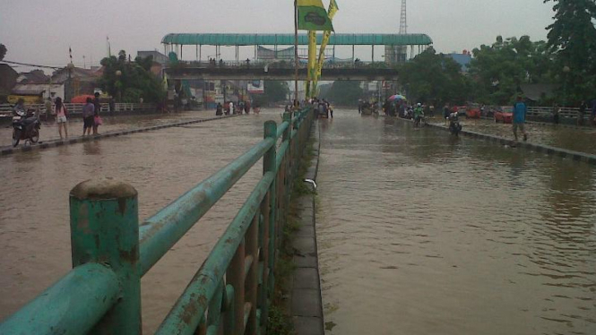 Luapan air Sungai Ciliwung menutup akses Jalan di Kampung Melayu, Jakarta Timur.