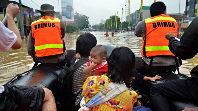 Petugas Brimob Bantu Evakuasi Korban Banjir