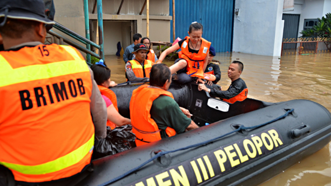Petugas Brimob Bantu Evakuasi Korban Banjir