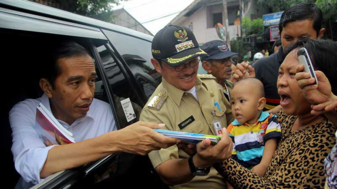 Pantau Luapan Kali Cipinang, Jokowi Bagikan Buku Tulis