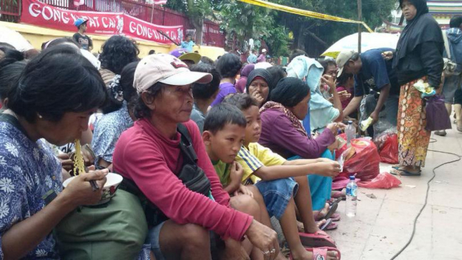 Warga menunggu pembagian angpau