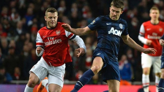 Jack Wilshere berduel dengan Michael Carrick.